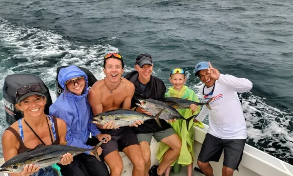 Happy group showing their catch on a Quepos fishing charter during a luxury sportfishing trip in Costa Rica.