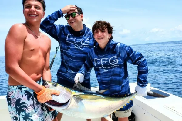 Anglers holding a yellowfin tuna on a Quepos fishing charter in Costa Rica.
